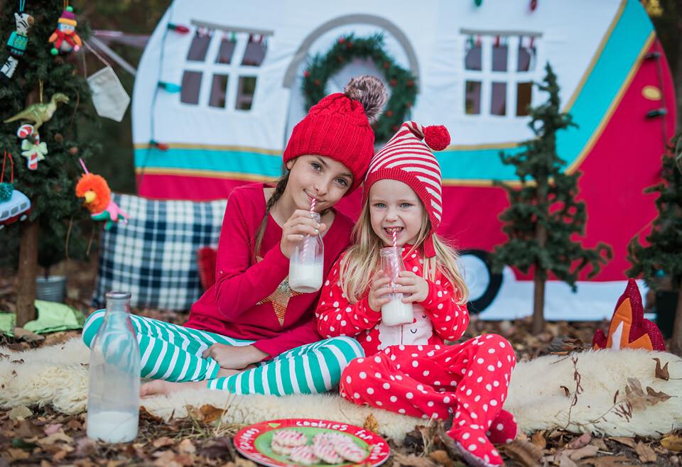 Sisters with milk and cookies for Santa during family photo shoot