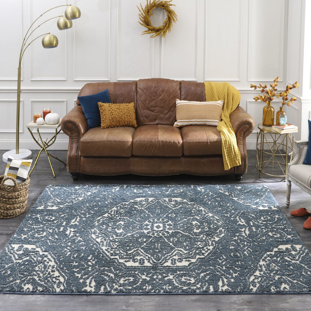 Blue Francesca area rug is shown with small sofa and single side chair. 