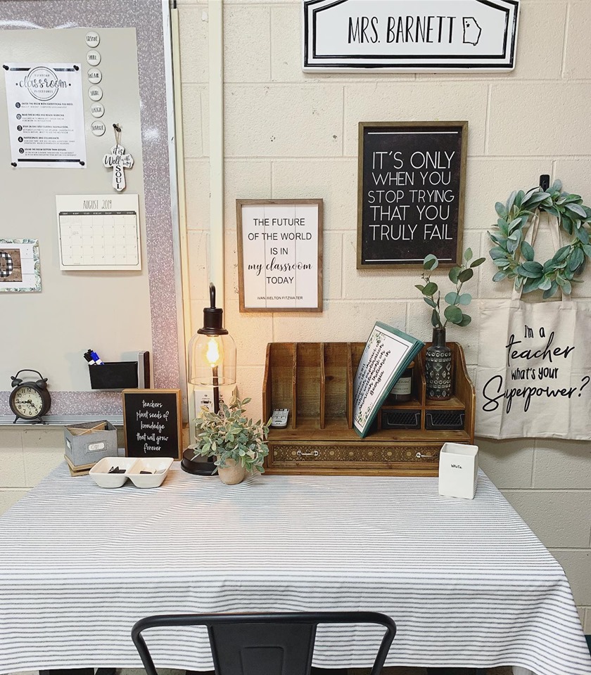 Adorable workspace with farmhouse accents like a eucalyptus wreath, Edison table lamp and wooden mail sorter.