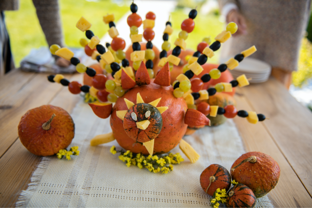 Edible turkey centerpiece made out of pumpkin and fruit skewers